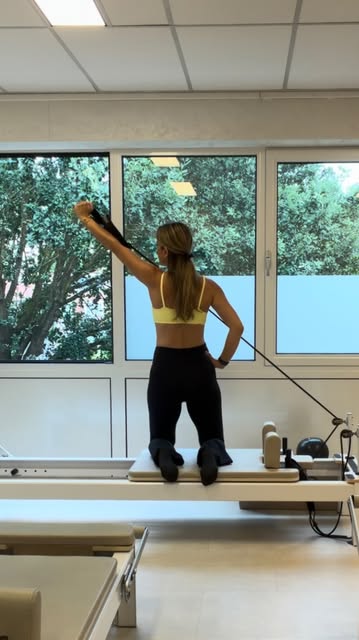 Cansu kneeling on a reformer, working with the straps